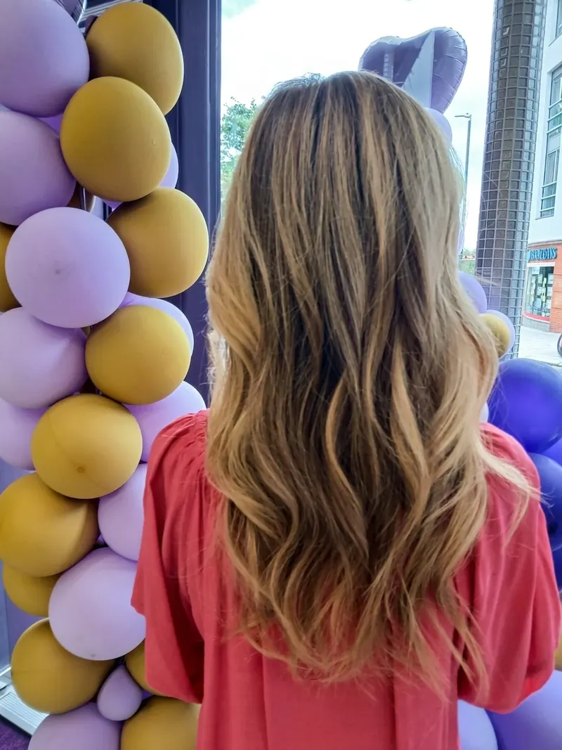 Long blonde balayage on wavy hair, hand-painted by Bobby